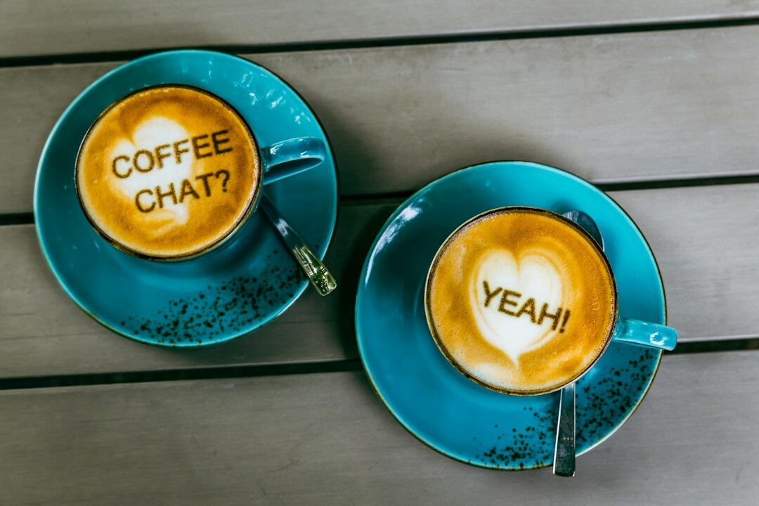 Two cups of coffee on a wooden table during a conversation