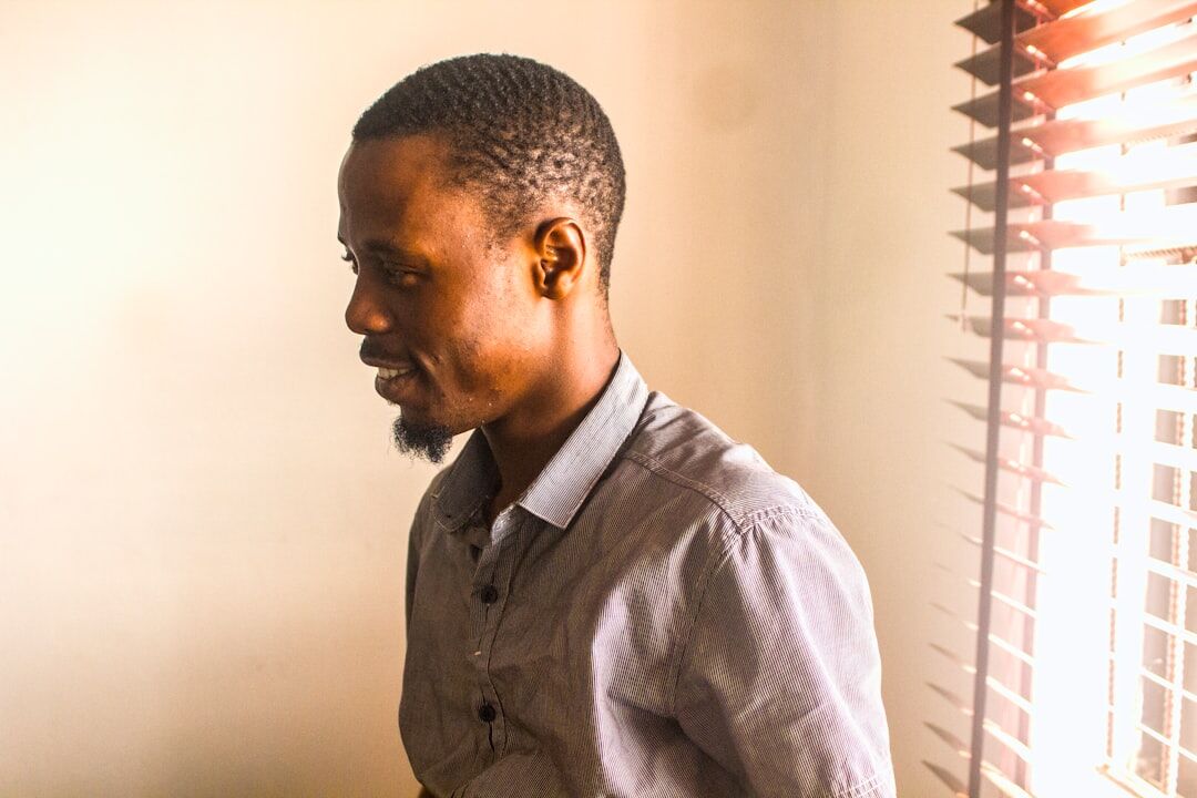 Belgian man of Congolese descent smiling warmly in an office setting